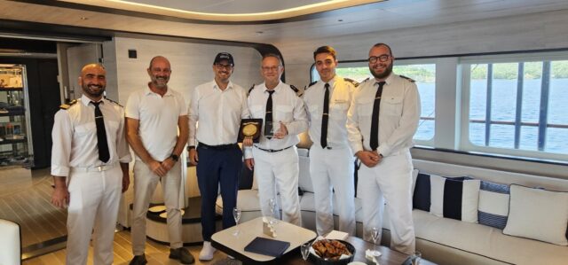 Το πλήρωμα πολυτελούς yacht κρουαζιέρας παραλαμβάνει αναμνηστική πλακέτα κατά την πρώτη άφιξη του σκάφους στον λιμένα Γαΐου Παξών.
