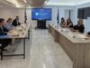 Στελέχη του Υπουργείου Τουρισμού και του ΣΕΤΕ σε συνάντηση εργασίας γύρω από τραπέζι, με την επωνυμία του Υπουργείου Τουρισμού σε οθόνη στο βάθος.