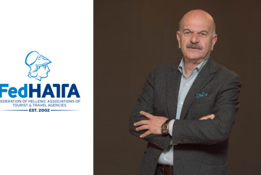 Ο πρόεδρος της FedHATTA, Λύσανδρος Τσιλίδης, με σταυρωμένα χέρια, δίπλα στο λογότυπο της Ομοσπονδίας.