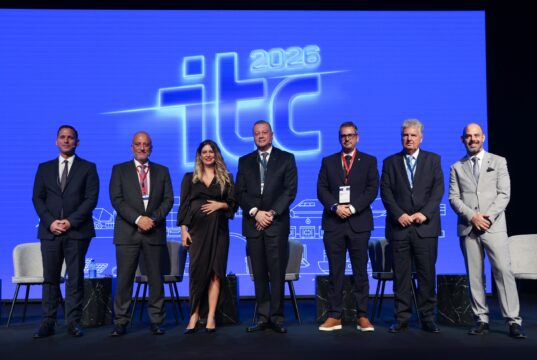 Panelists and moderator pose on stage in front of the ITC 2026 logo at the 9th Infrastructure and Transport Conference in Athens.