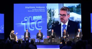 Ο Διευθύνων Σύμβουλος του Οργανισμού Λιμένος Κέρκυρας Δημήτρης Απέργης προβάλλεται στη μεγάλη οθόνη κατά το πάνελ του 9ου Συνεδρίου Υποδομών και Μεταφορών ITC 2026.
